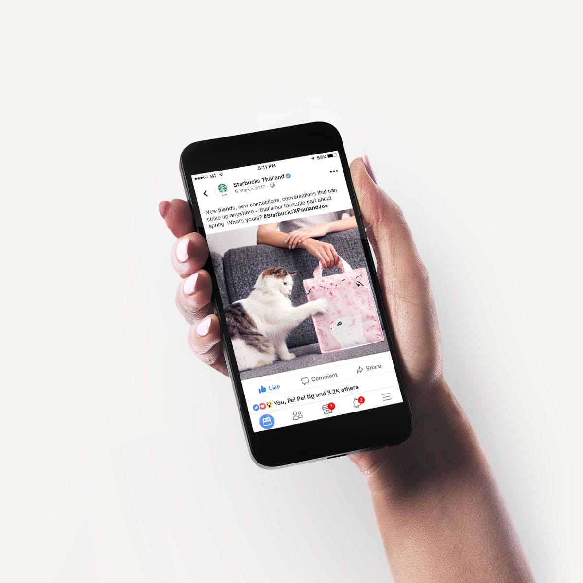 A hand holding a mobile phone with a social post on the screen